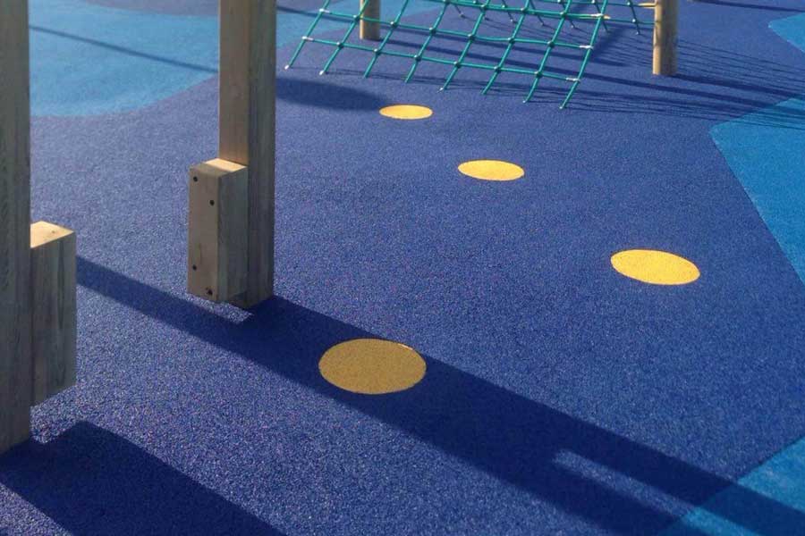 Rubber crumb surfacing with colours and shapes in a play area